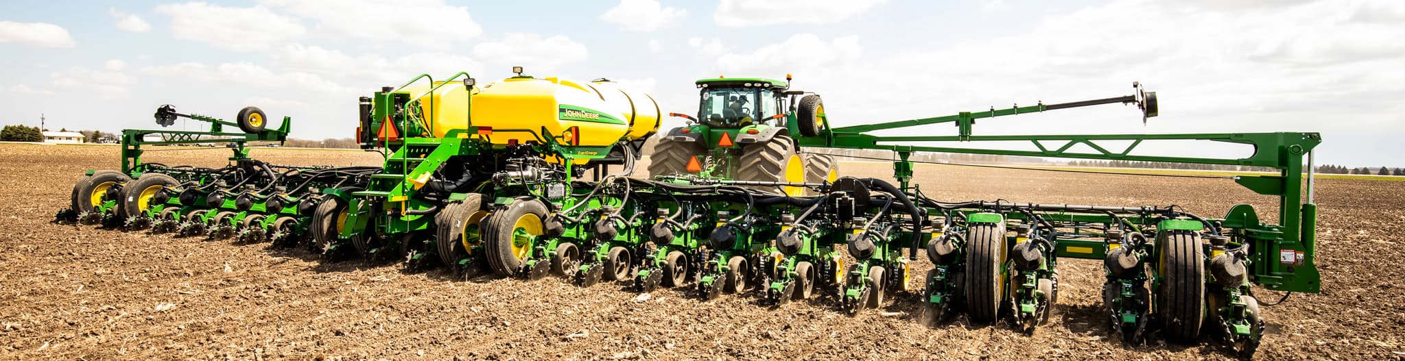 Tractor pulling planter attachment through a field