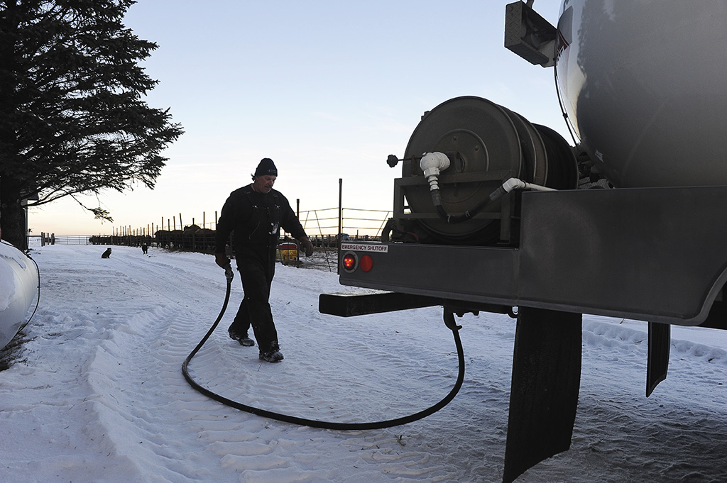 Man walking hose back to a propane truck