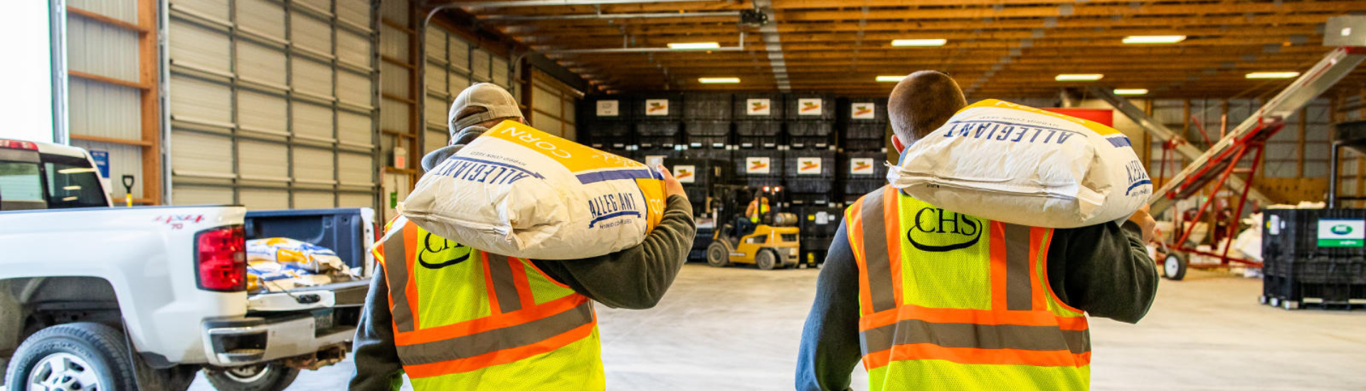 Two men carrying seed bags