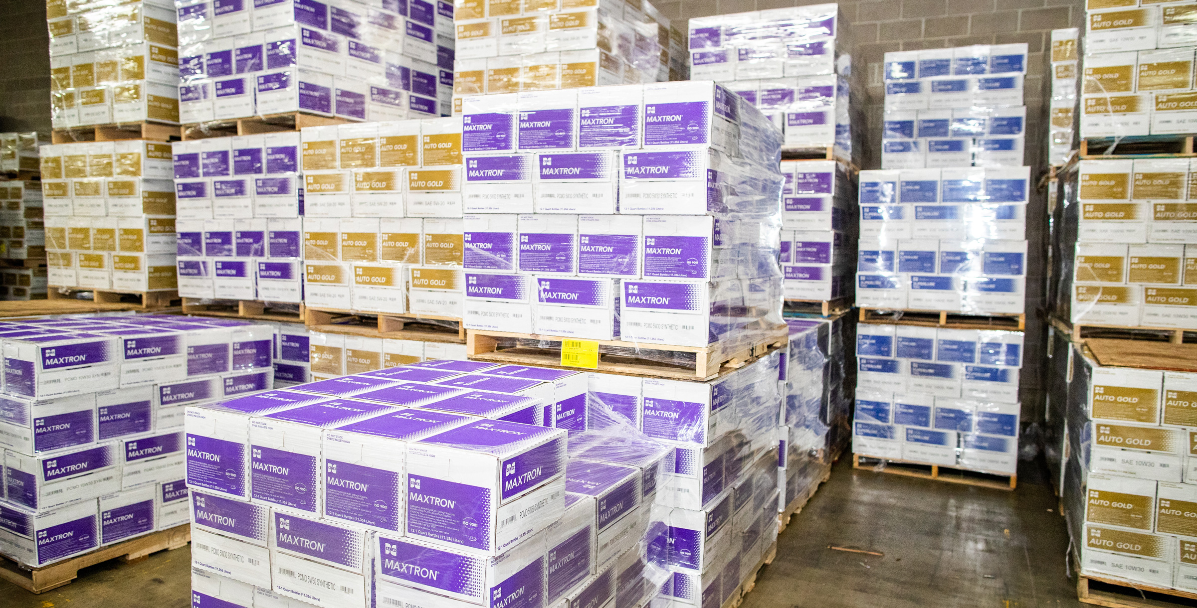 Maxtron and Autogold product boxes sitting on pallents in a warehouse